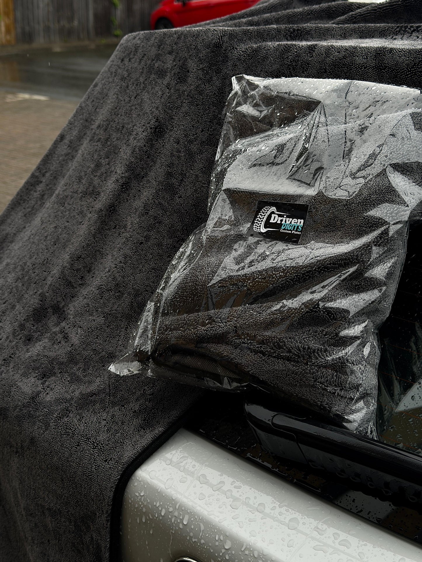 Brand new car drying towel in its packaging laid on top on car by Driven Digits